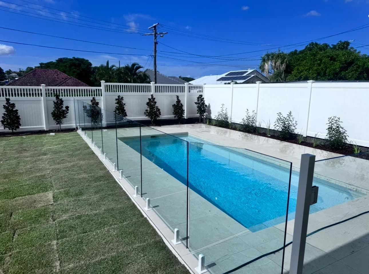Full privacy PVC fence enclosing backyard with pool and glass fence